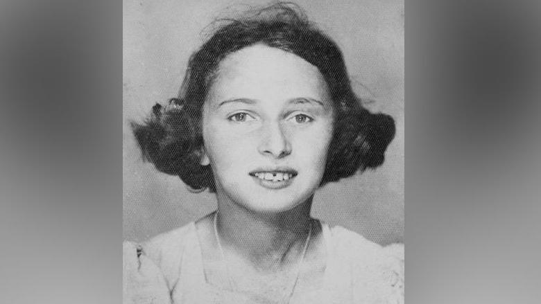 Susan Pollack pictured in black and white as a girl aged about 12 to 13. She is wearing a pale frilly top/dress, and a necklace. She has short dark hair that is bouncing out at the edges, as per the style of the 1930s.