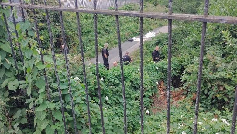Police officers are seen looking through bushes and plants along a cycle path around the Tang Hall area. The picture has been taken from a height above the officers, through black railings. A white object is also placed on the cycle path.