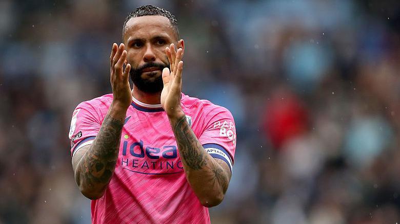 Kyle Bartley, in his pink West Bromwich Albion shirt, claps the fans after a game