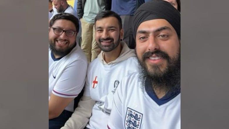 Jag Singh with his friend and brother-in-law smile at the camera at the stadium in Dusseldorf. They are all wearing England shirts.