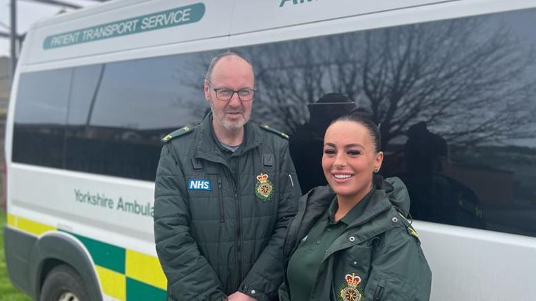 Megan Jordan and Andrew Beverley standing next to their patient Transport Service vehicle