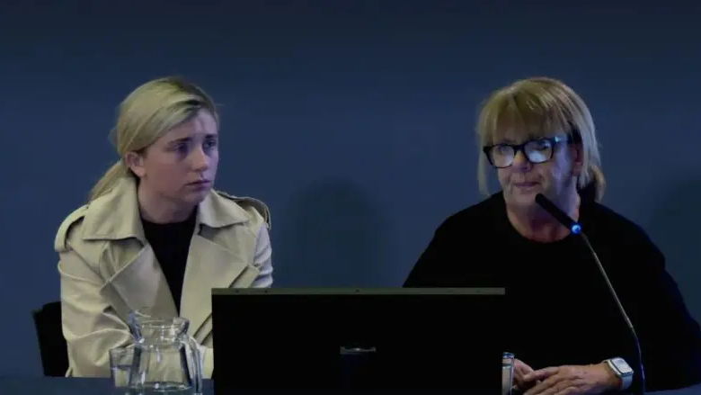 Caroline McKinney (right) and her daughter. Caroline has blonde hair with a fringe, wearing glasses and a black jumper. Her daughter has blonde hair tied back, wearing a beige raincoat and a black top.