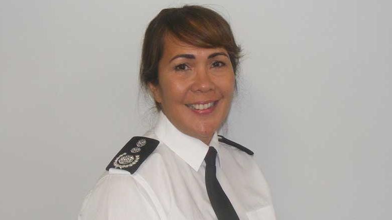 Buckinghamshire Chief Fire Officer Louise Harrison. She is wearing a white shirt, a black tie and on her shoulders can be seen black epaulettes, one of which can be seen with the fire service log. She is turned towards the viewer with her left shoulder forward. She has dark hair pulled back, a fringe over her forehead and is smiling