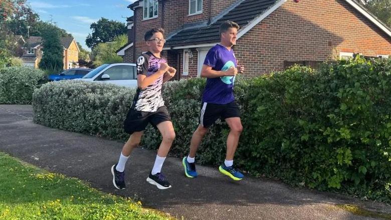 Zac and his dad James running along a residential street