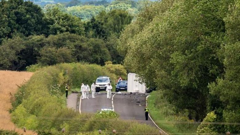 A photo of forensic investigation officers at the crash scene