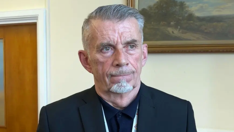 Councillor Richard Brown wears a black shirt and jacket. He has short grey hair and a grey goatee beard.