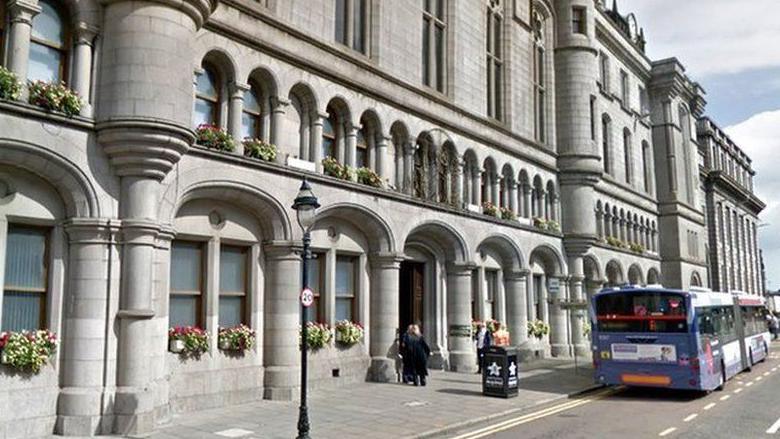 Aberdeen Sheriff Court building, bus beside it, flowers on windows