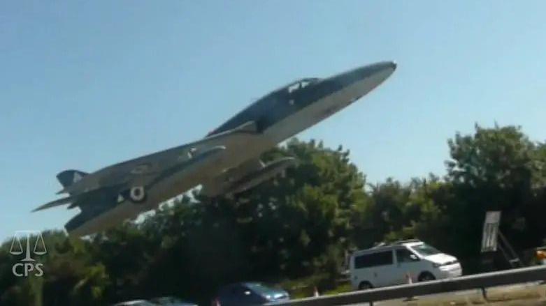 A jet plane metres above a road with cars on it