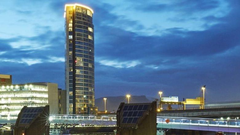 Image of tall glass building at dusk.