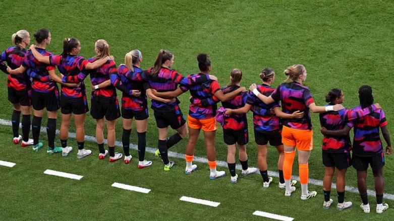 England's substitutes with their hands round each other's shoulders on the touchline 