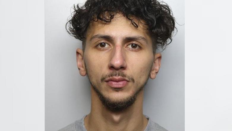 A custody photo of Leonard David who has black curly hair, brown eyes and goatee