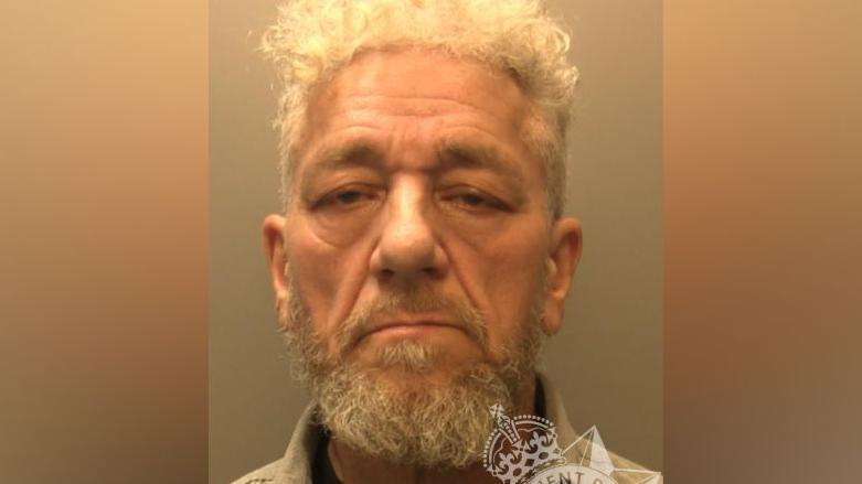 Antonio Villafane's mugshot. He has a beard and is not smiling