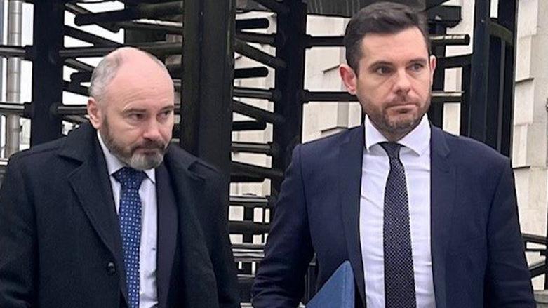 Lee Williamson (left) and his solicitor Michael Madden both in suts stand outside a court