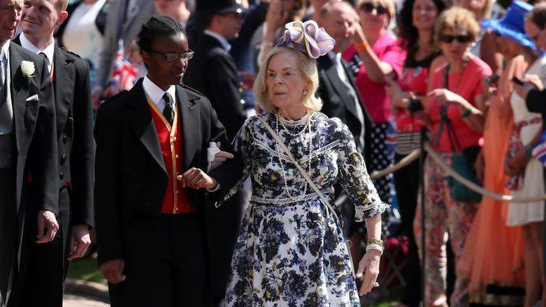 The Duchess of Kent arriving at Prince Harry's wedding. She is being helped to her seat by an usher.