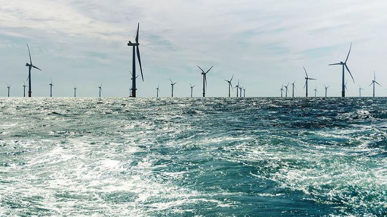 Multiple wind turbines at sea.