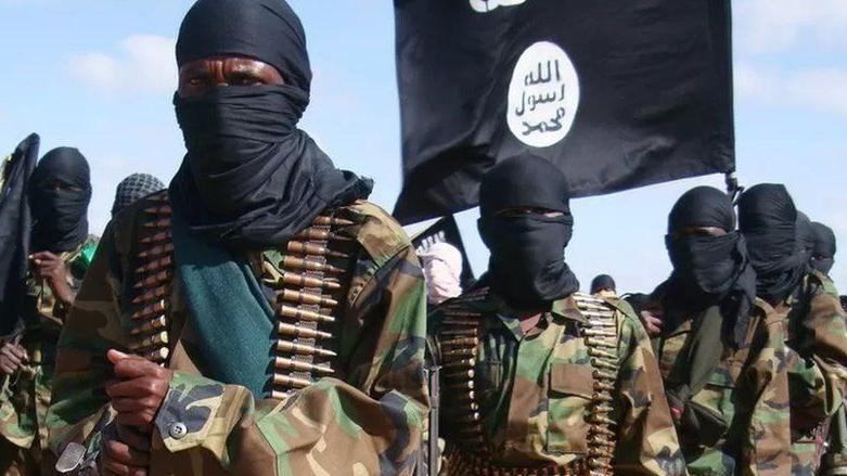 Masked al-Shabab fighters carrying a black flag and ammunition strapped around their bodies