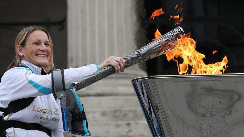 Claire Lomas lighting a cauldron as part of the torch relay for the Paralympic Games in 2012