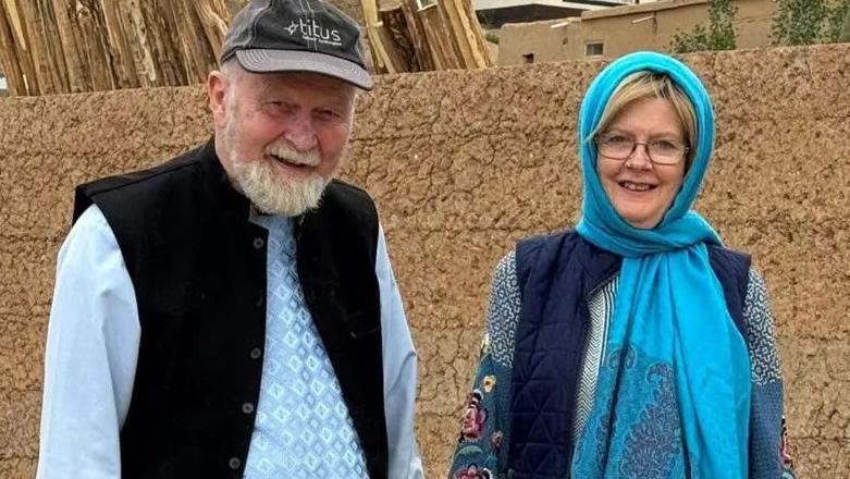 Peter and Barbie Reynolds, an elderly couple, smile at the camera.