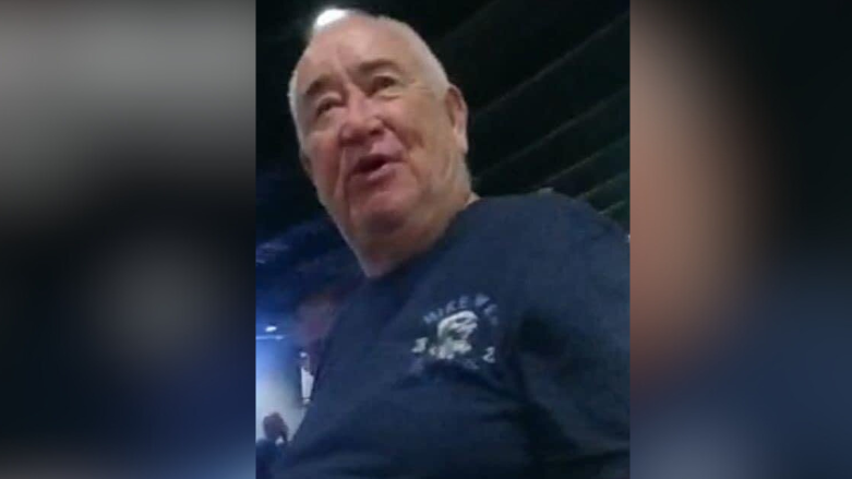 A still image of Liam Mackin. He has his mouth open and is talking to someone behind the camera. He is sitting in a bar and is wearing a navy t-shirt.