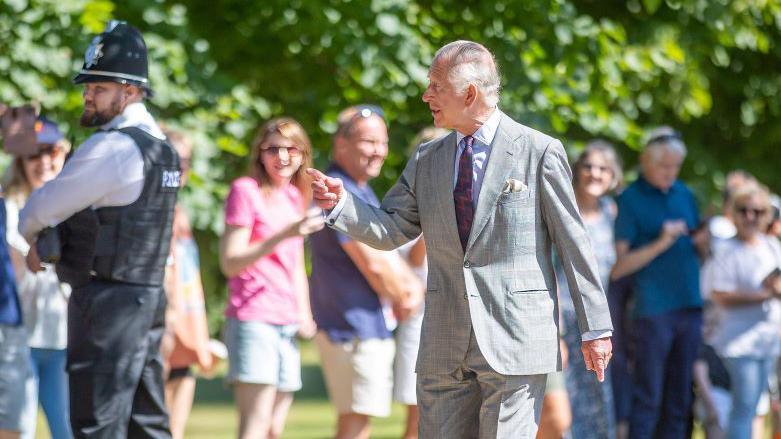 King Charles walking to church on Sandringham estate.