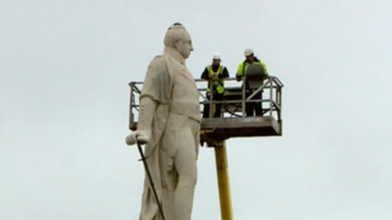 Workers examine the Lord Hill statue