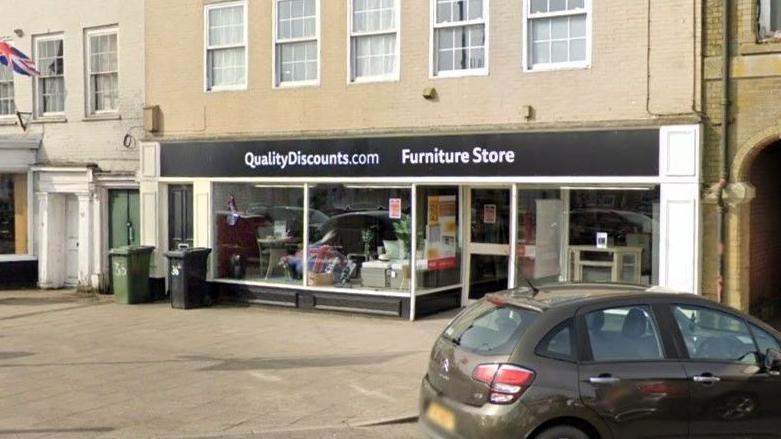 A shop front which says "Quality Discounts dot com" and "Furniture store"