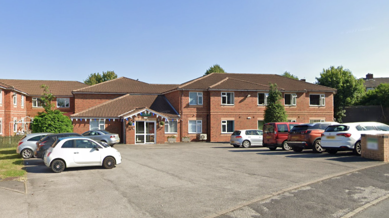 Byron Lodge care home in Rotherham. It is a two-storey brick building. There is bunting around the entrance. There are around 10 cars in the car park out front.