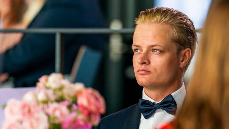 A 2022 image showing a young man with blond hair and a bow tie