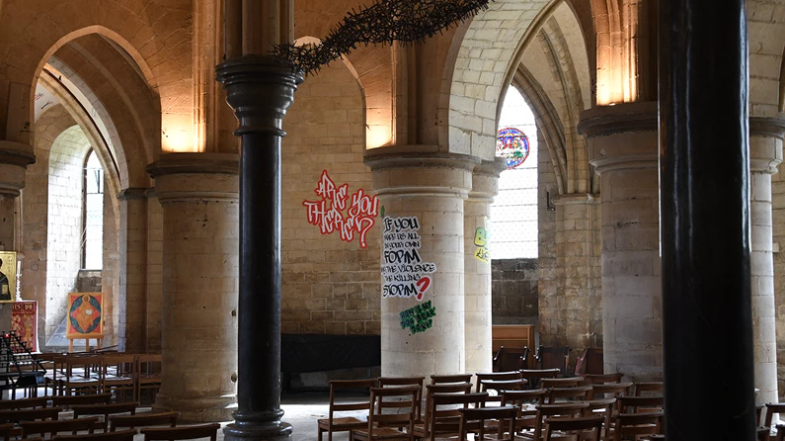 Graffiti-style writing is on the inside of a historic church.