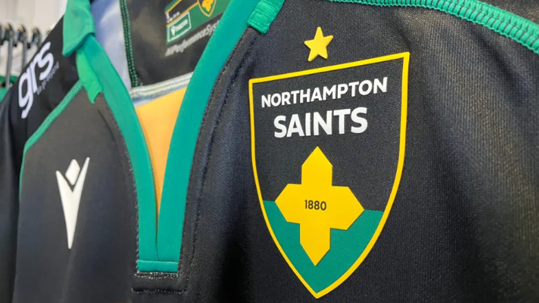 Northampton Saints' rugby shirt with a close-up of crest showing a yellow cross.