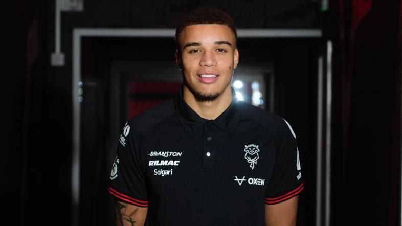 Ryan One stood in a darkened player tunnel at the LNER Stadium in Lincoln City training gear