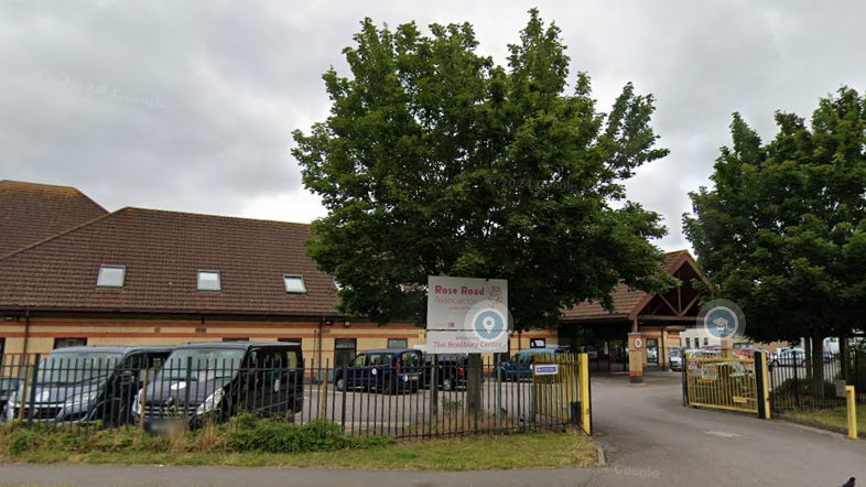 The beige coloured brick work of the charity's premises in Southampton. Iron railings can be seen at the front of the building, along with several parked vehicles and taxis.
