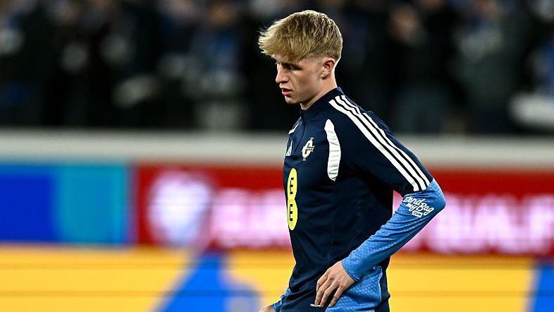 Tom Atcheson in a dark blue Northern Ireland training top warming up before a World Cup play off against Italy in March.