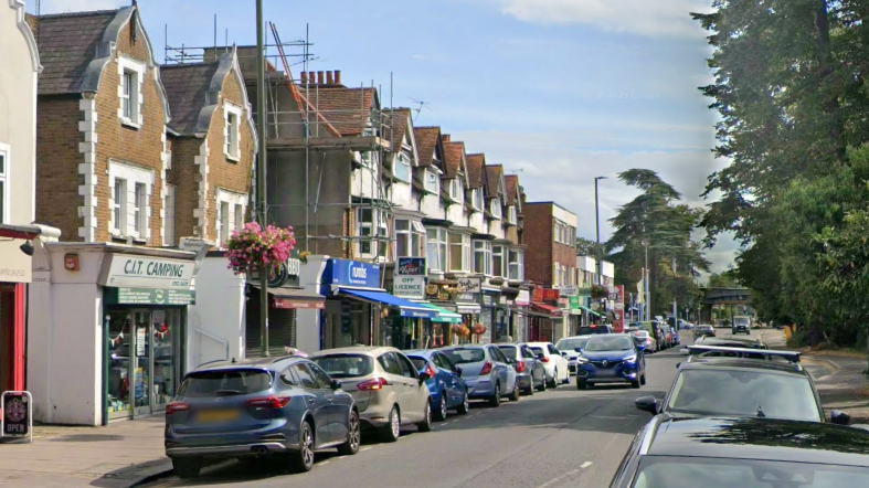 A Google Street image of a high street with cars parked along the side of the road.