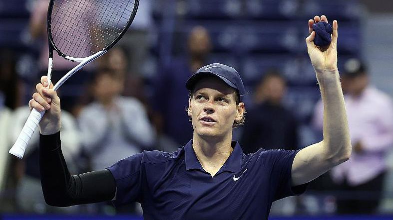 Jannik Sinner raises his arms in celebration