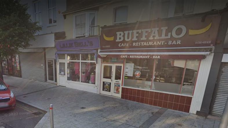 A brown shop front on a roadside with a sign that reads "Buffalo"