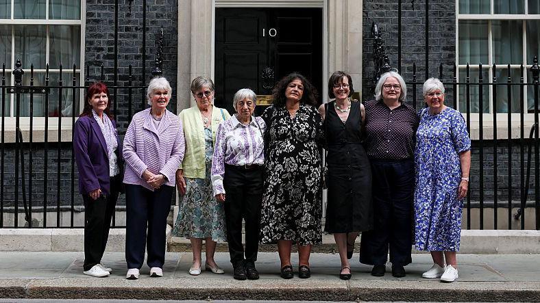 Seven campaigners pose for a photograph after a meeting with British Prime Minister Keir Starmer to discuss historical forced adoption, outside 10 Downing Street on July 02, 2026