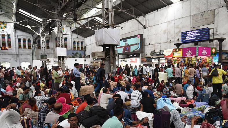 Hundreds of passengers waiting at the Sealdah South Section railway station in Kolkata city after local trains were cancelled following heavy rain