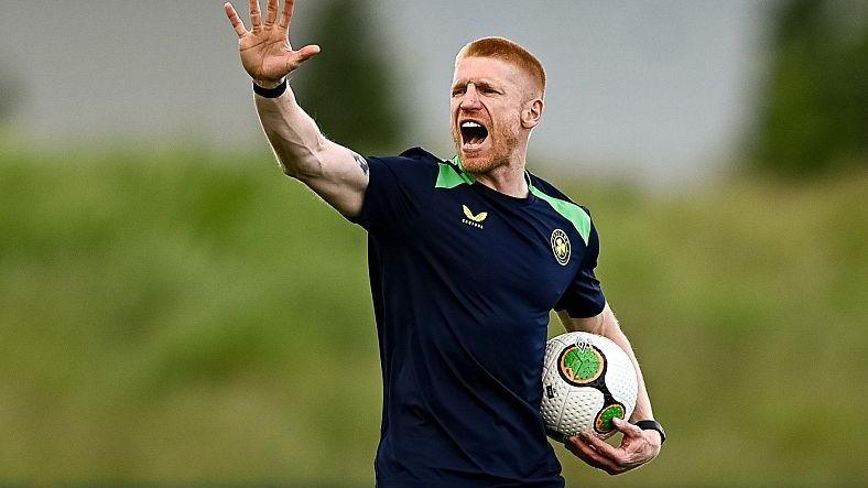 Paul McShane wearing a navy blue Republic of Ireland training top waves and shouts instructions during a training session