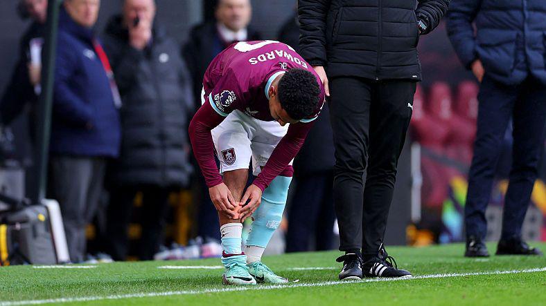 Marcus Edwards putting a small shin pad on