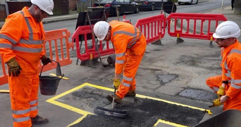 Workers repairing potholes