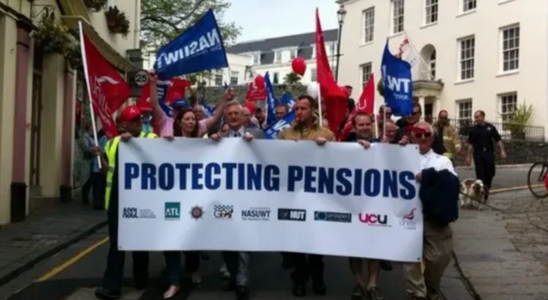 A group of people holding a banner which says protecting pensions, with flags waving in the background. 