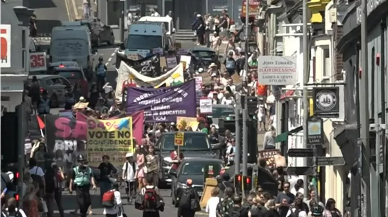 Protesters holding banners and marching in protest against redundancies