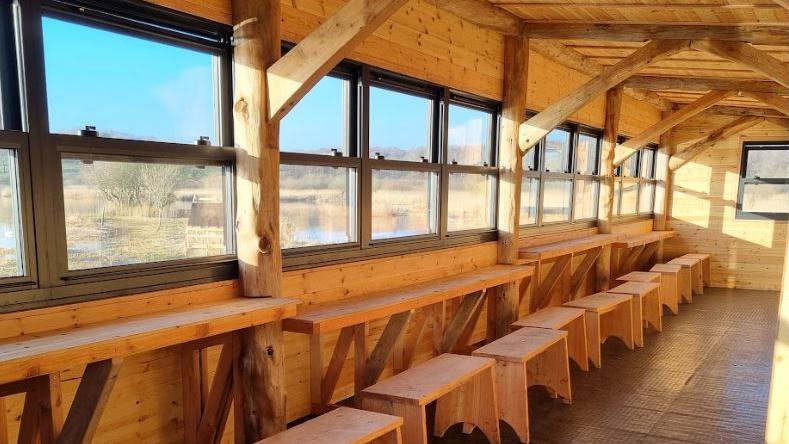 Inside a newly rebuilt bird watching hide looking out on to the Lower Pool at RSPB Leighton Moss nature reserve.