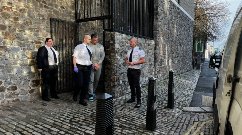 Paul Butler, 53, of Stangray Avenue, Plymouth, being escorted out of Plymouth Magistrates Court on Monday 27 January. He is wearing a grey tracksuit and blue flip flops. He is being escorted by three prison officers.