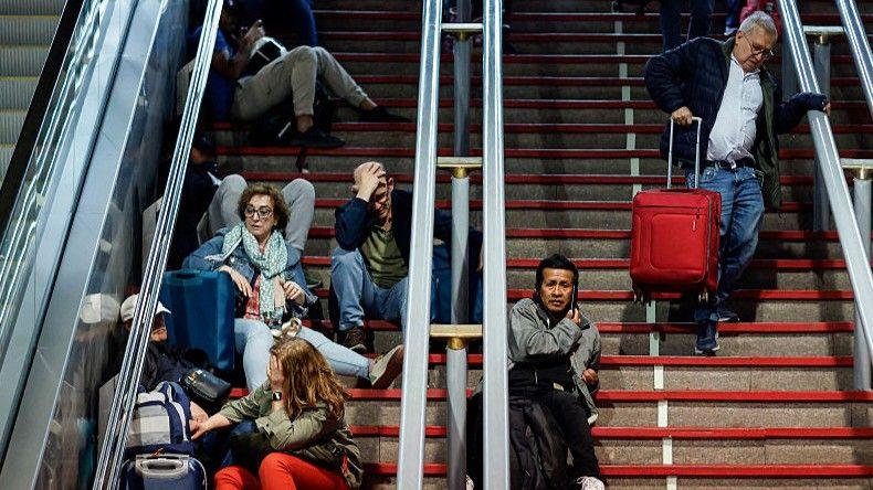 Passengers looking stressed while sitting on the steps of Atocha train station during April's power cut.