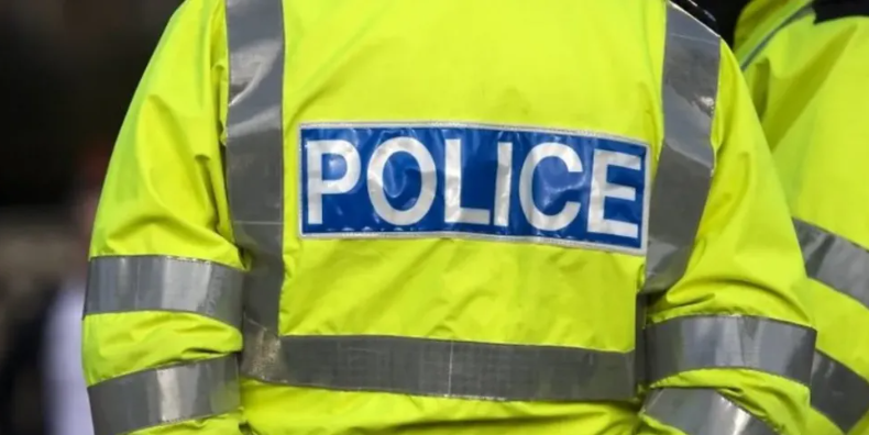 The back of a policeman wearing a high-vis jacket with the word 'police' on