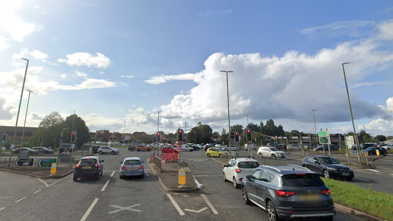 A Google Streetview screenshot of the busy junction of Cole Avenue and Bristol Road. There are multiple lanes of traffic on each carriageway, meeting at a four-way intersection. 