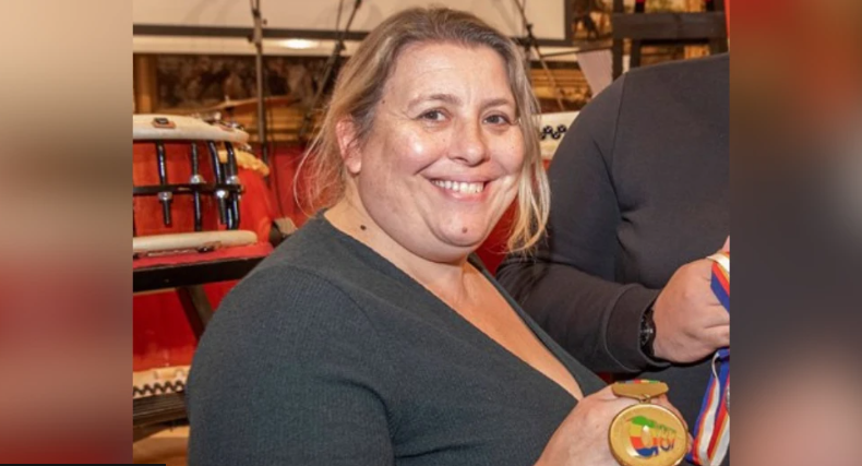 A picture of a smiling woman holding a medal