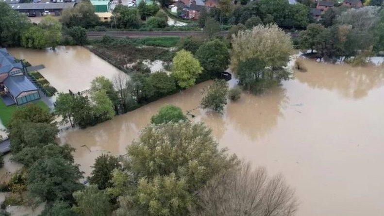 Flooded fields and water surrounding a home